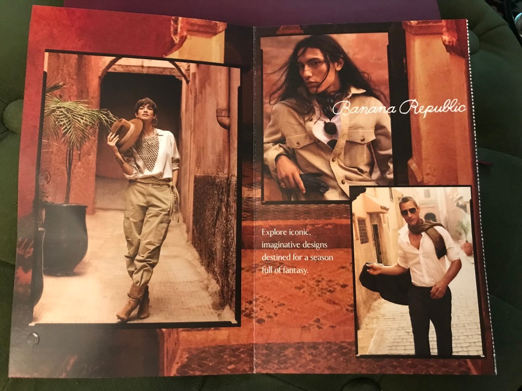 Inside of the Banana Republic advertisement. Three images of white people, one who has a vaguely exotic appearance with olive skin and long brown hair. All wear shades of white and khaki and brown and are styled like adventurers or explorers. They stand in a reddish, sandstone place of indeterminate location. The text reads: Explore iconic, imaginative designs destined for a season full of fantasy.